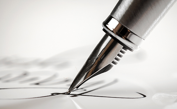Graphic image of pen signing signature on paper.