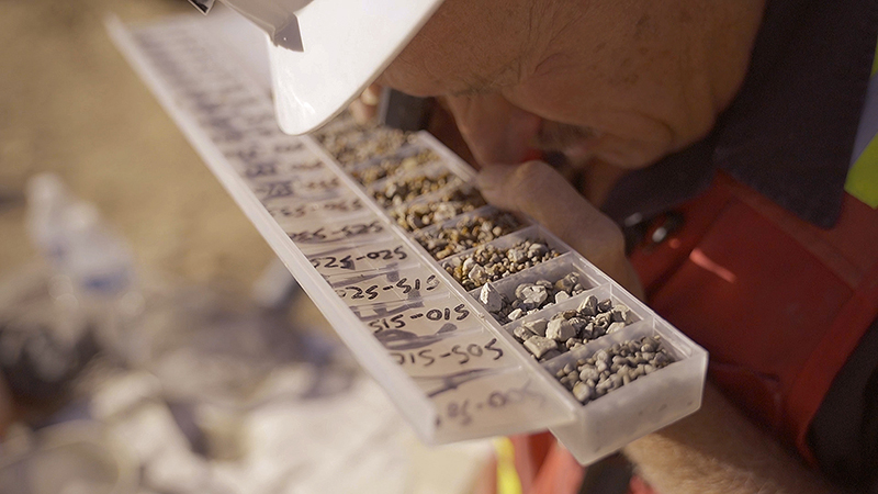 Image of worker inspecting gold samples.